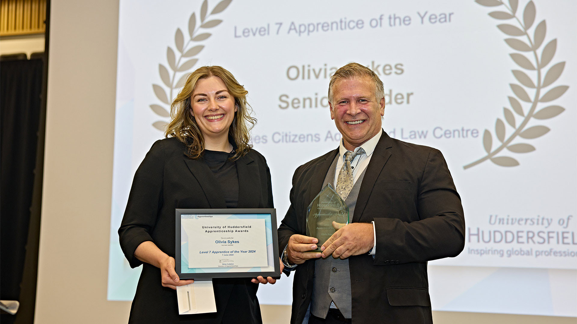 Olivia Sykes smiling and holding her level 7 apprenticeship award