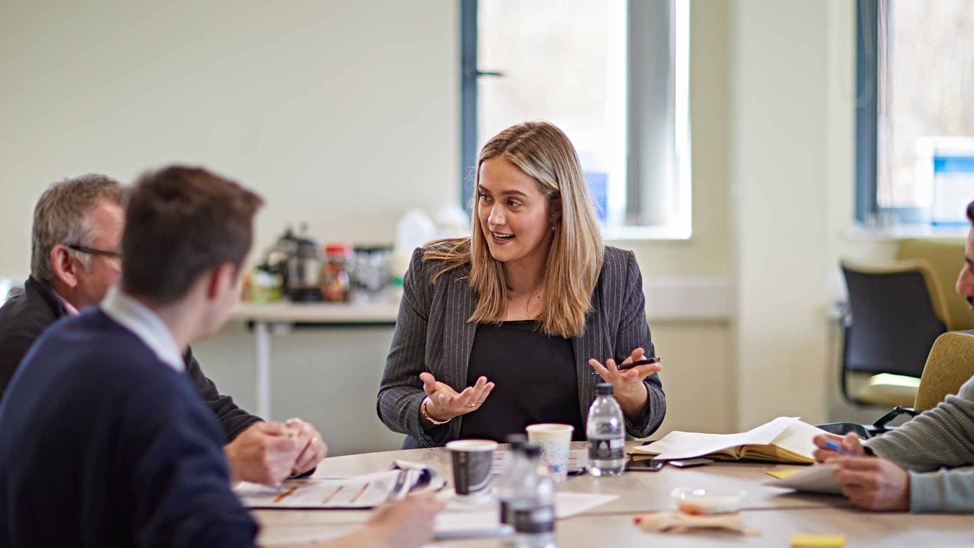 Colleagues in a meeting sat around a table