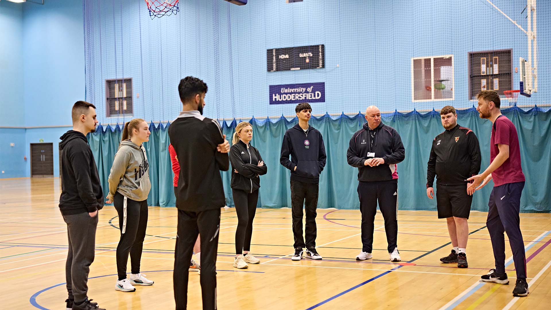 Group of PE students and PE teacher in a sports hall