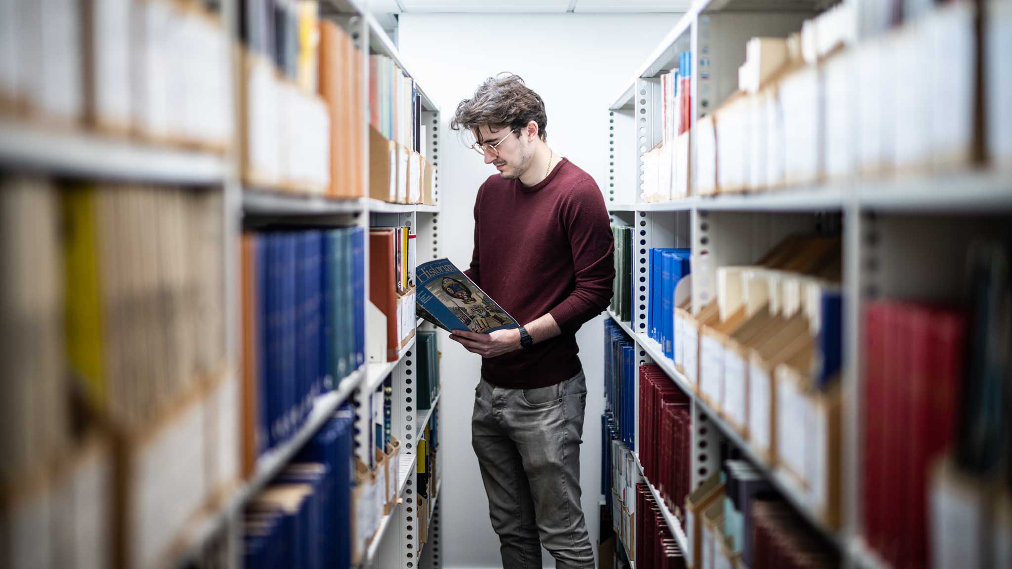 A student reading a book in our library