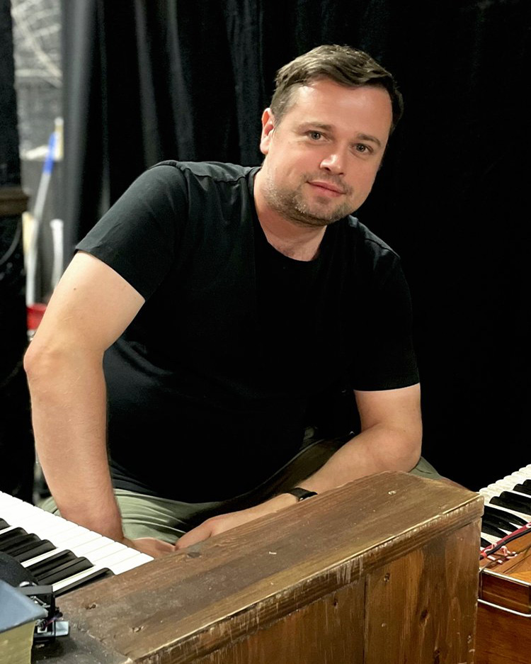 Graduate, Andrew, sat at a keyboard