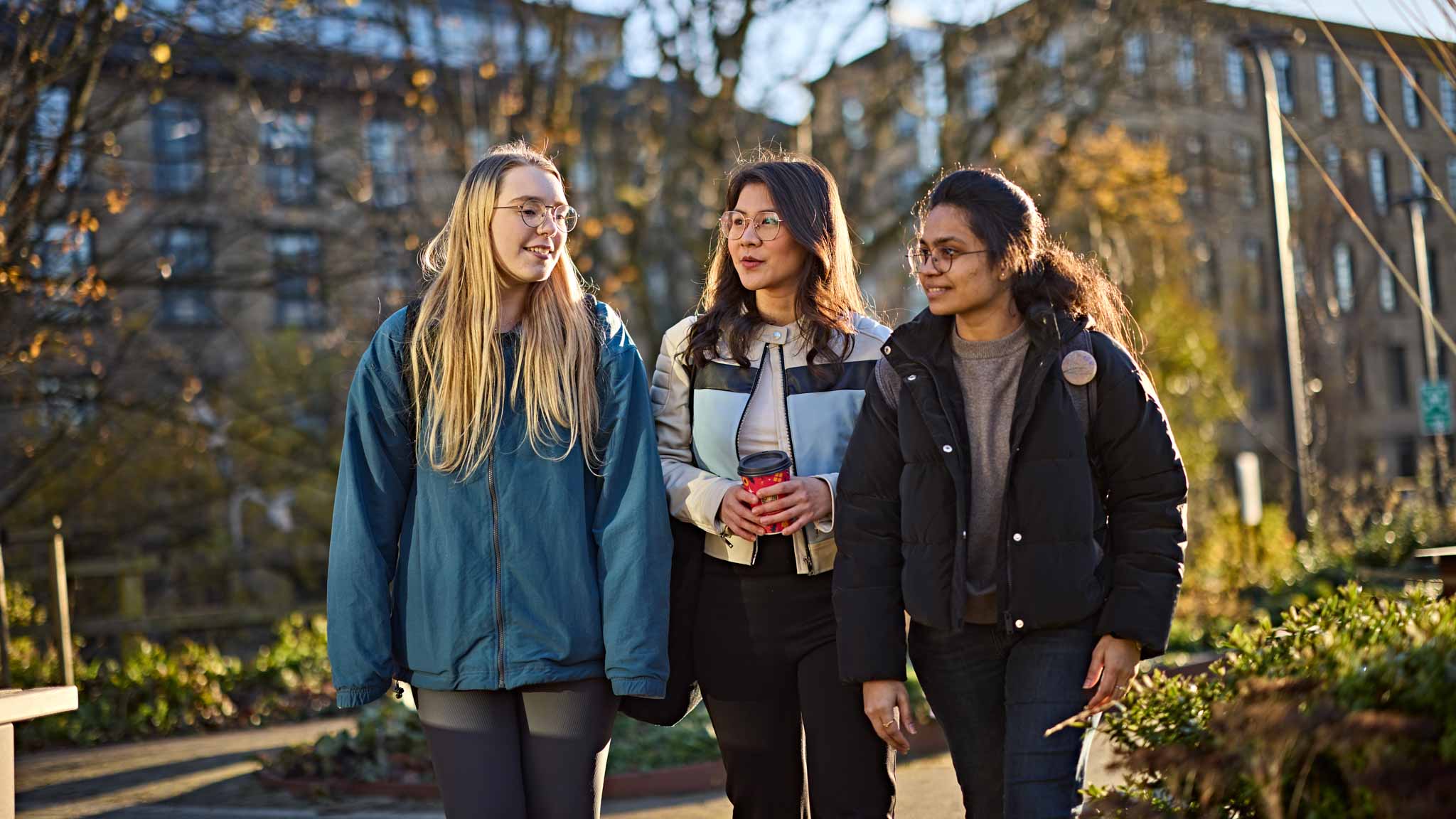 Students walking across campus talking to eachother
