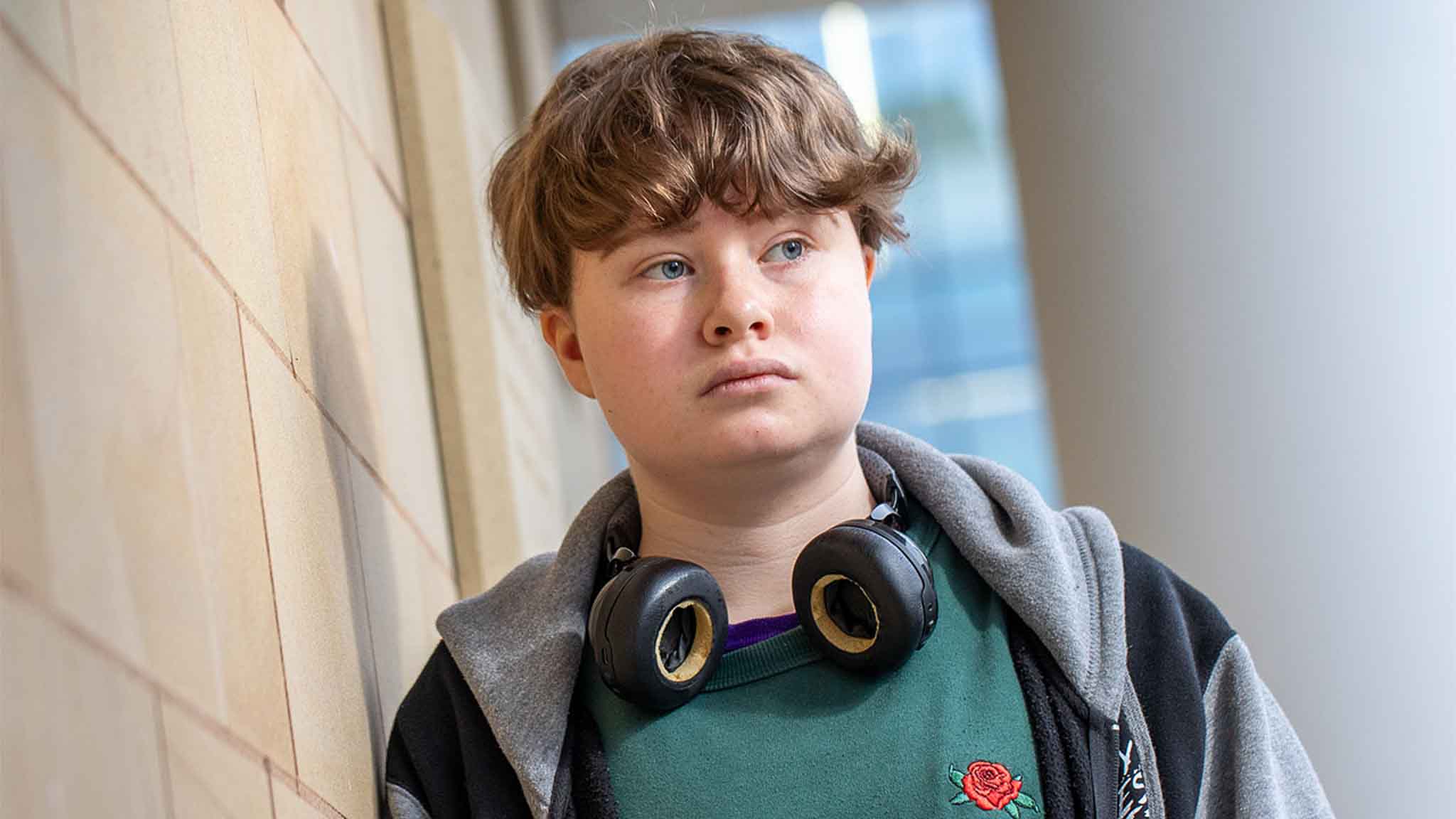 A student standing against a wall