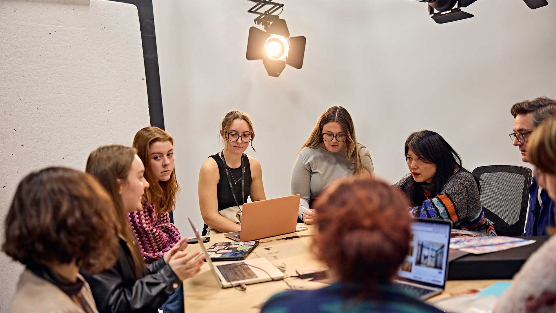 A group of photography students in a meeting in a collaborative space