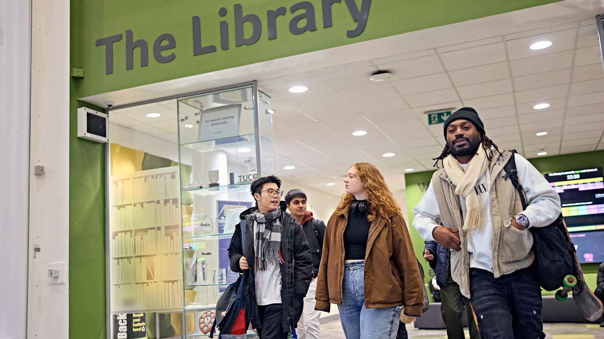 A range of students outside the library