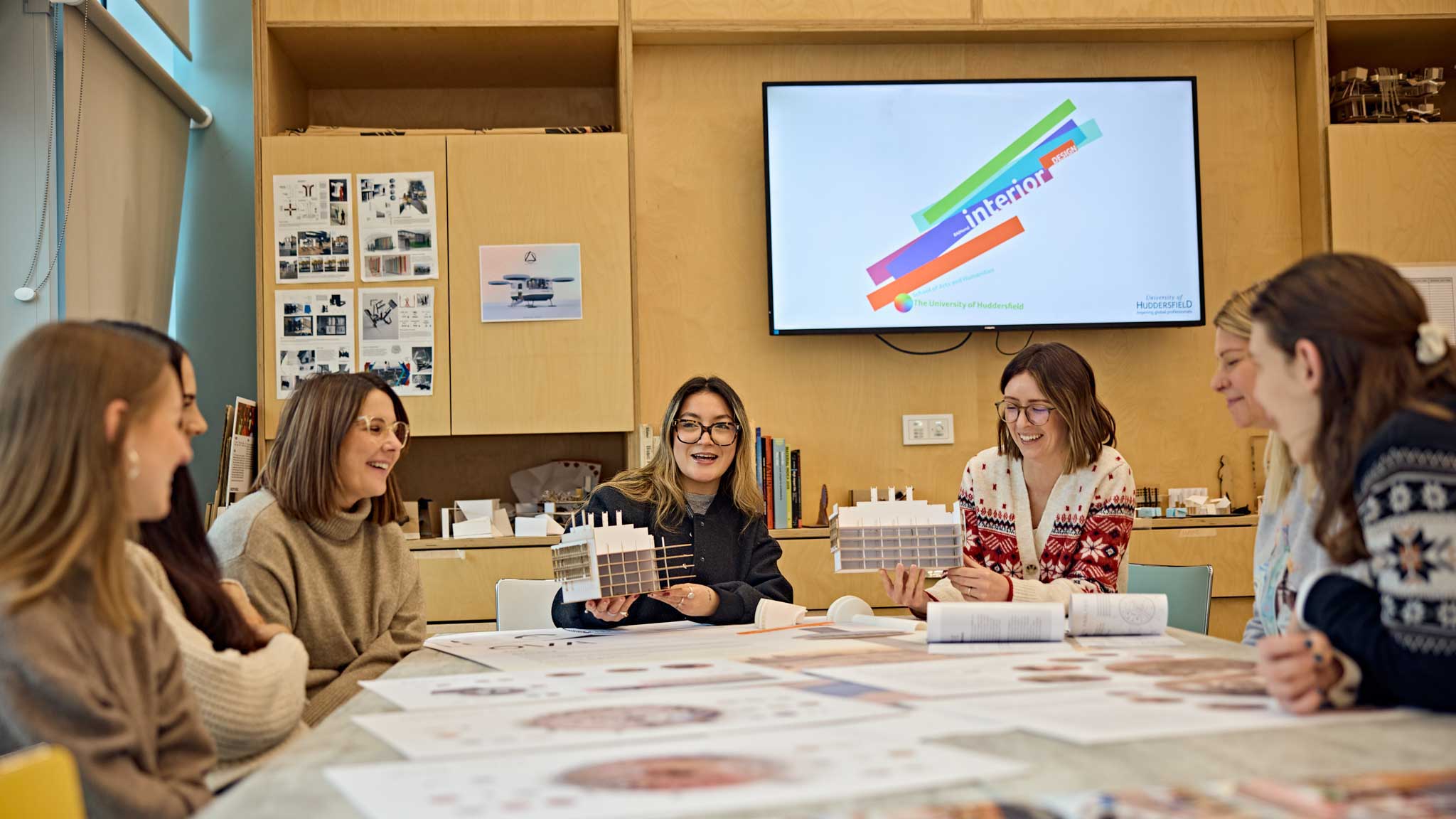 Seven students sat around discussing there interior design projects